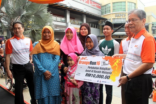 Tan Sri Dato' Seri Lodin bin Wok Kamaruddin presenting a mock cheque to Pertubuhan Kebajikan Asnaf Al Barakh Malaysia